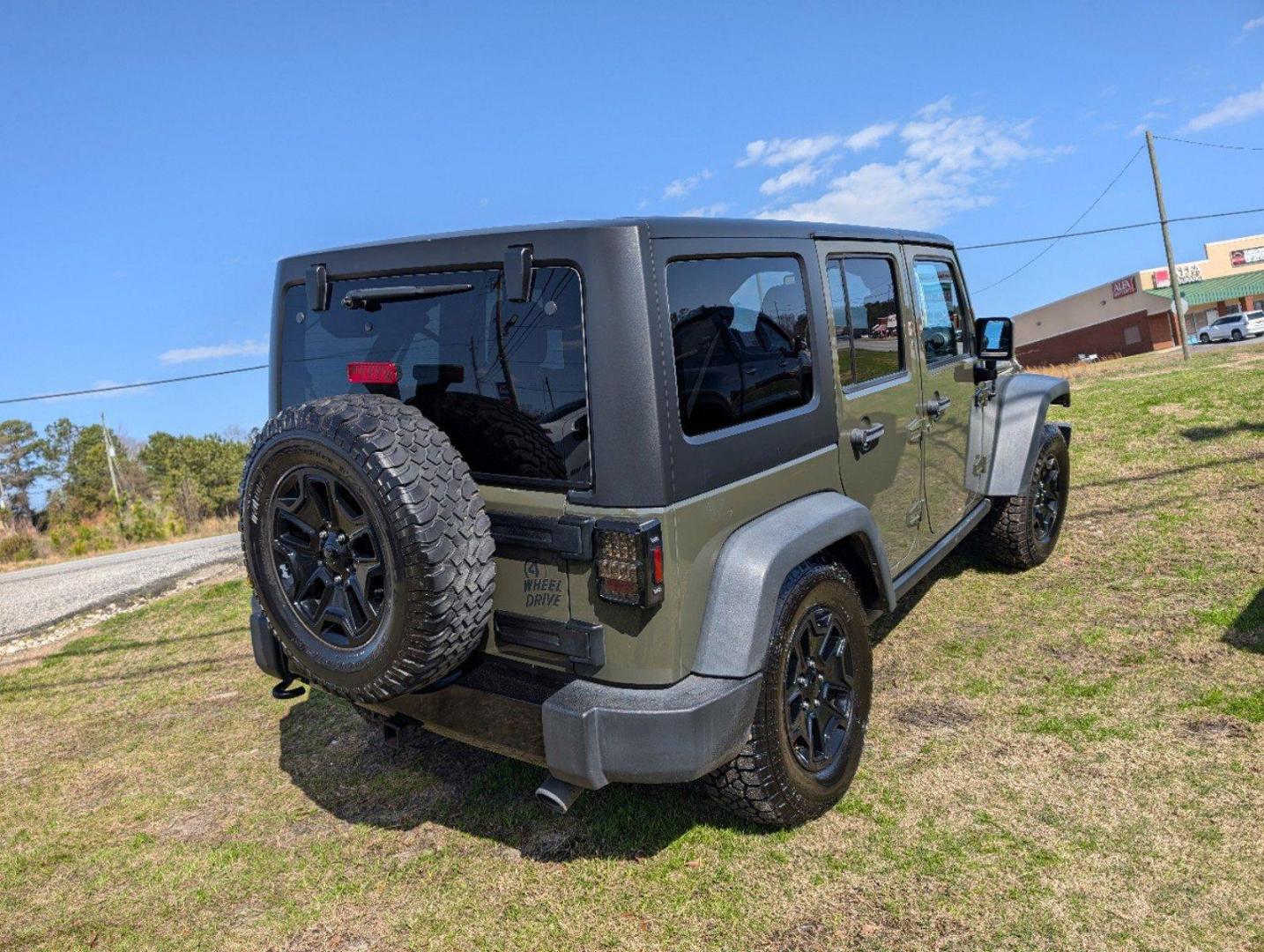 2016 /Black Jeep Wrangler Unlimited Willys Wheeler (1C4BJWDG9GL) with an Regular Unleaded V-6 3.6 L/220 engine, 6-Speed Manual w/OD transmission, located at 804 22nd Ave, Phenix City, AL, 36870, (334) 297-1860, 32.484749, -85.024475 - 2016 Jeep Wrangler Unlimited Willys Wheeler - Photo#4